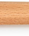 A close-up of a light natural wood paddle or spatula handle with a slot cutout at the top and the brand name 'LE CREUSET' printed in dark lettering on the side.