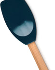 A silicone spatula with a dark teal-blue head and a light natural wood handle, shown diagonally on a plain white background.