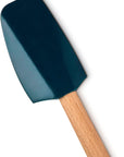 A silicone spatula with a dark teal-blue blade and a light natural wood handle, shown diagonally on a plain white background.