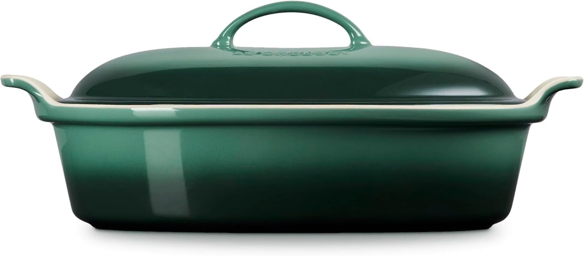 Side view of green oven dish with a lid on a white background