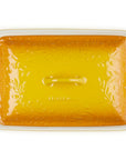 A rectangular glass baking dish with a lid, featuring a vibrant yellow-orange floral pattern on the lid and a white glass base with side handles, shown on a solid white background.