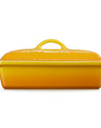 A rectangular yellow ceramic casserole dish with a matching lid, featuring side handles and a top handle, shown against a plain white background.