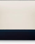 A rectangular enameled baking dish with a deep blue exterior and a cream-colored interior, featuring two side handles.