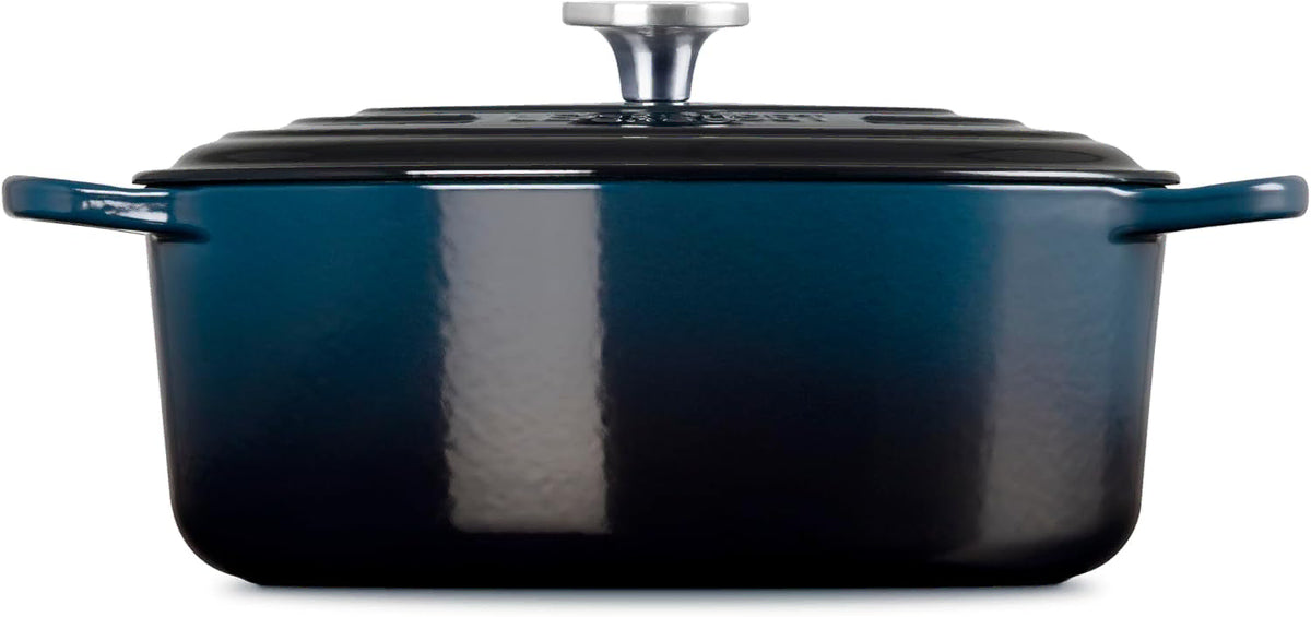 Side view of a dark teal enameled cast iron Dutch oven with a matching lid and silver knob, shown on a plain white background.
