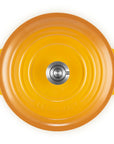A top-down view of a bright yellow-orange enameled cast iron pot or Dutch oven with two side handles and a matching lid, set against a plain white background.