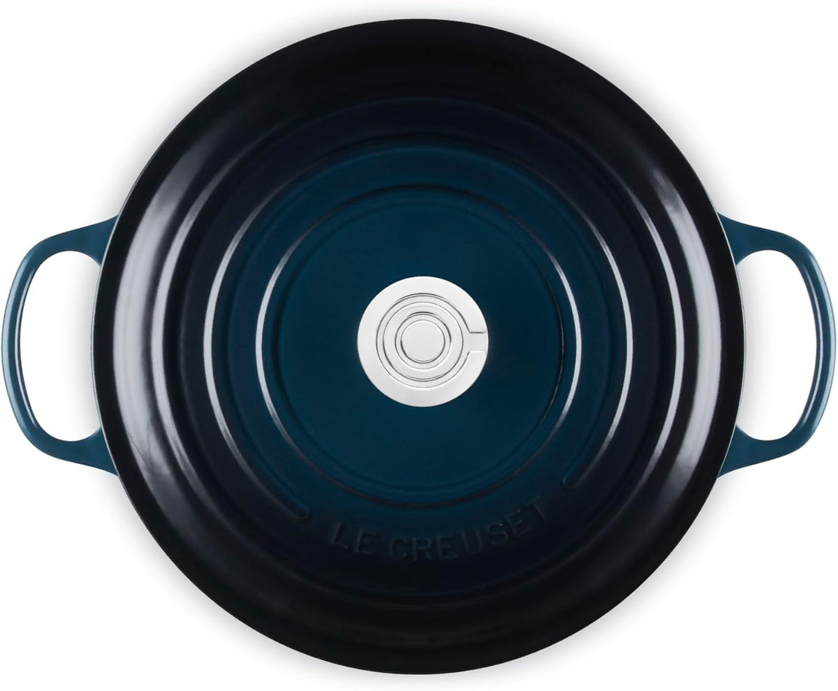 A top-down view of a dark blue enameled cast iron pot or Dutch oven with two side handles and a matching lid, set against a plain white background.