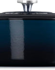 Side view of a dark blue enameled cast iron Dutch oven with a matching lid and silver knob, shown on a plain white background.