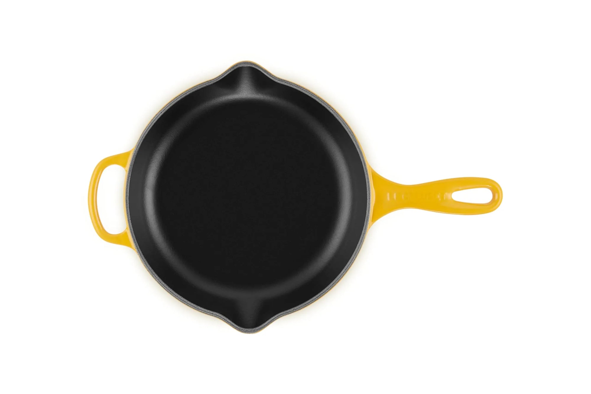 A top-down view of a yellow cast iron skillet with a black non-stick interior, featuring a yellow handle and a small yellow bail on the left side, set against a plain white background.