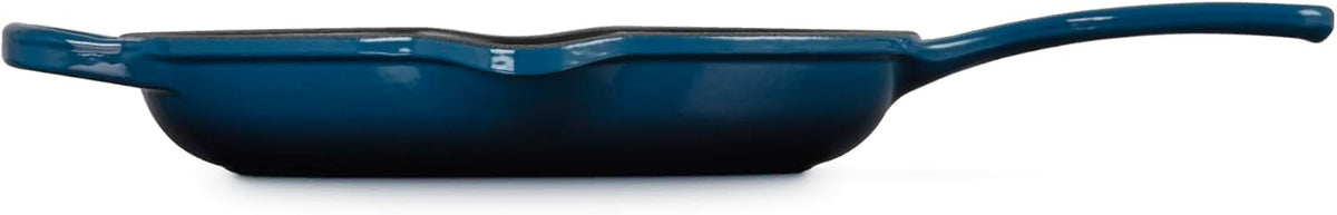 Side view of a dark blue cast iron skillet with a long handle, shown from a side profile view against a white background.
