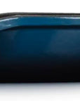 Side view of a dark blue cast iron skillet with a long handle, shown from a side profile view against a white background.