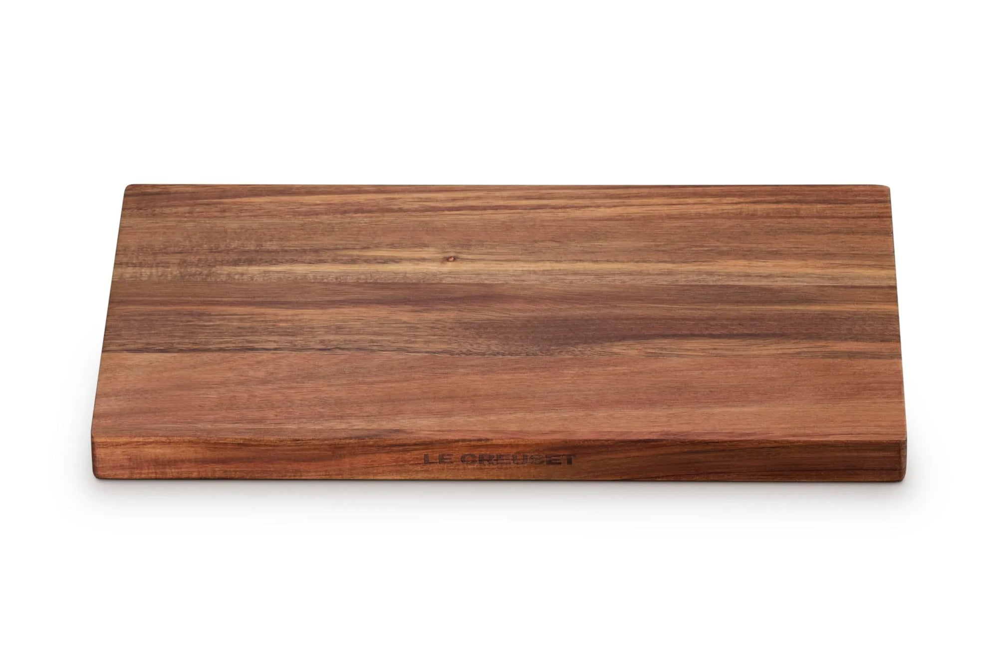 A rectangular wooden serving board with a rich brown wood grain pattern, featuring the 'LE CREUSET' brand name engraved near the bottom edge, set against a plain white background.