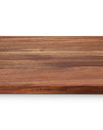 A rectangular wooden serving board with a rich brown wood grain pattern, featuring the 'LE CREUSET' brand name engraved near the bottom edge, set against a plain white background.