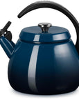 A glossy dark blue enamel kettle with a black curved handle and spout lid, shown on a clean white background.