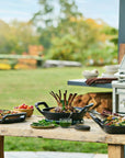 Outdoor setting with a grill, table, and food preparation area.