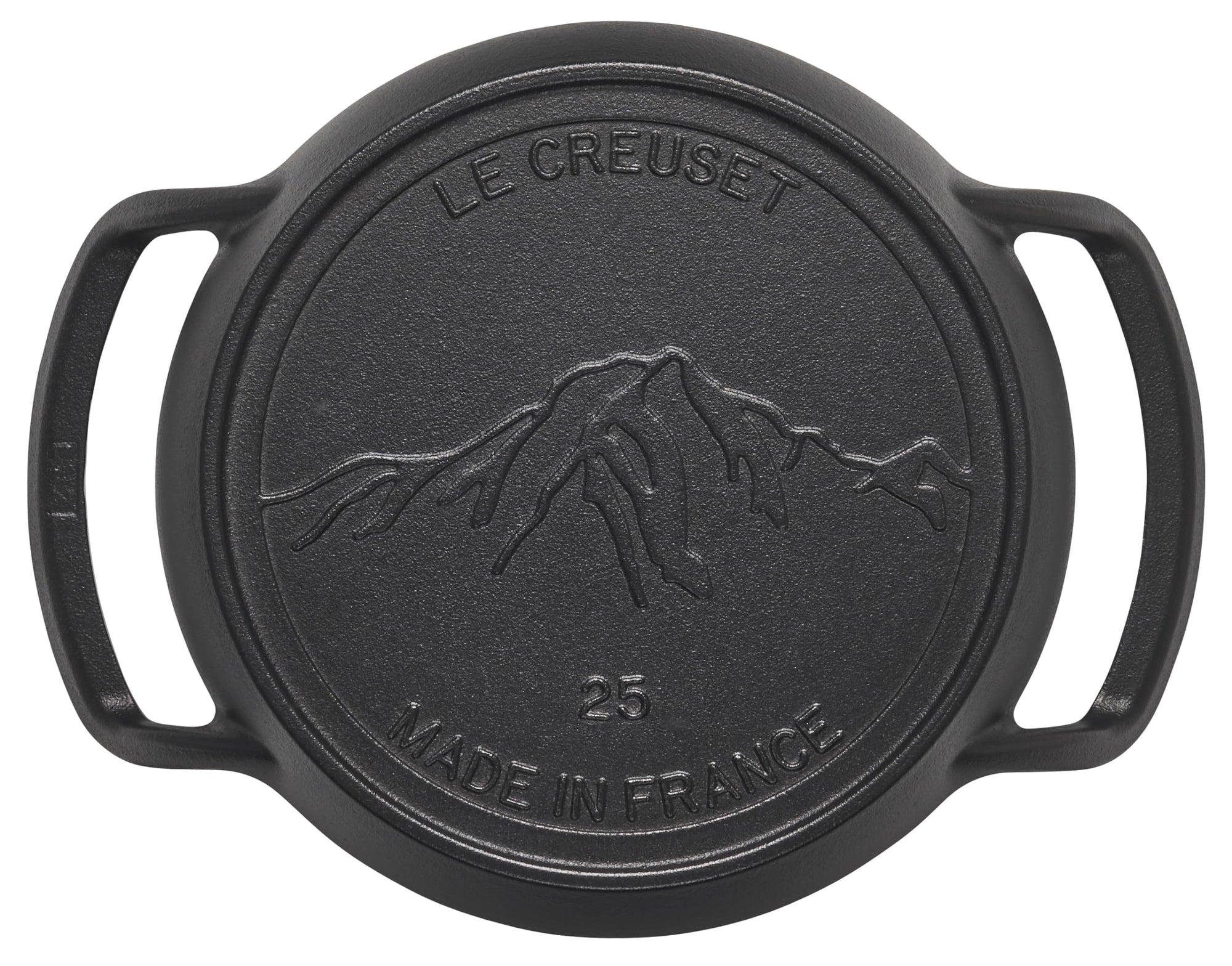 Black cast iron lid with mountain design and 'Le Creuset' branding on a white background