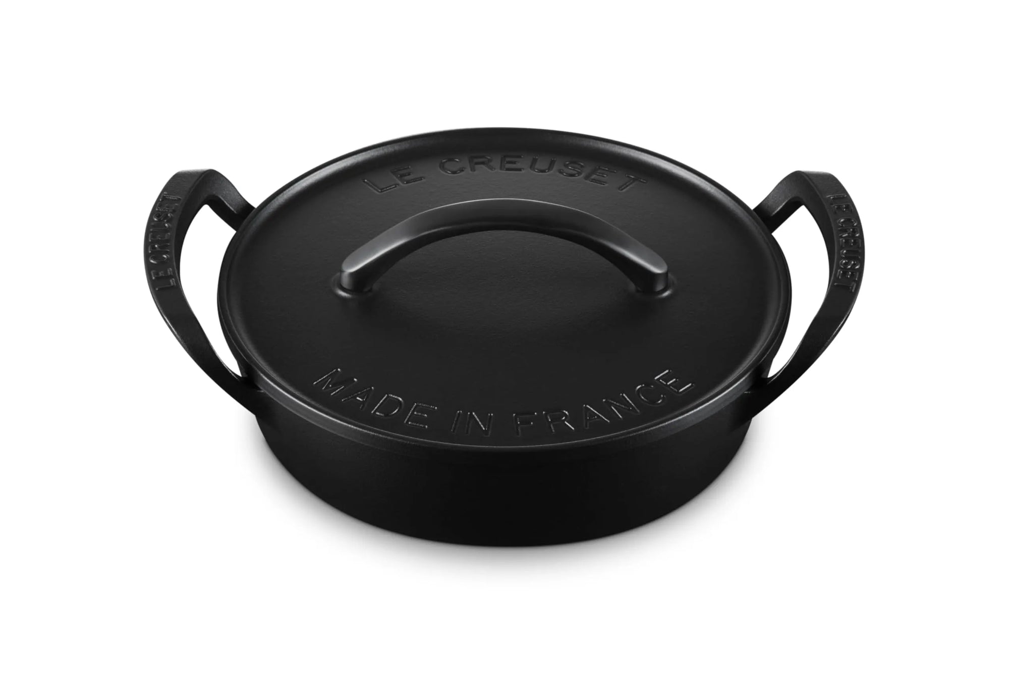 Black cast iron utility pan with 'Le Creuset' branding on a white background