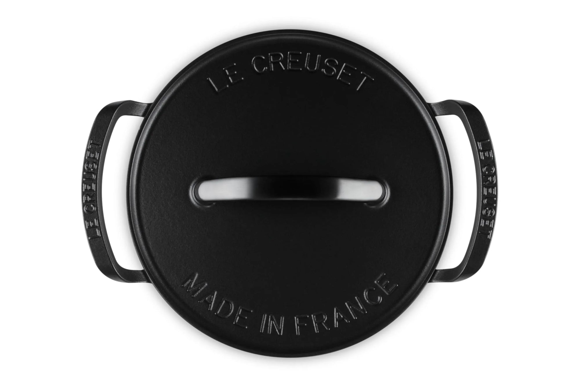 A black Le Creuset round lidded pot shown from a top-down view on a white background, featuring embossed branding and the text 'MADE IN FRANCE'.