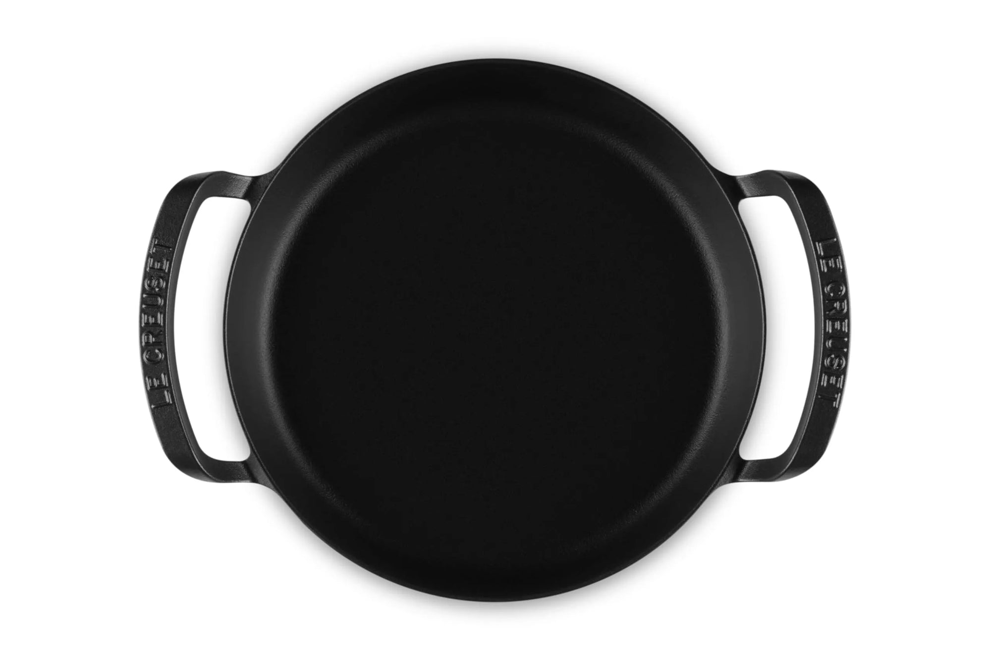 A black cast iron utility pan with two side handles, photographed from a top-down perspective on a solid white background.