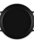 A black cast iron utility pan with two side handles, photographed from a top-down perspective on a solid white background.