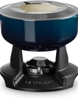 Le Creuset enameled cast iron pot with lid, shown on a black burner base against a white background.