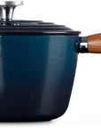 Side view of a dark blue enameled cast iron saucepan with a wooden handle and a matching lid, shown on a plain white background.