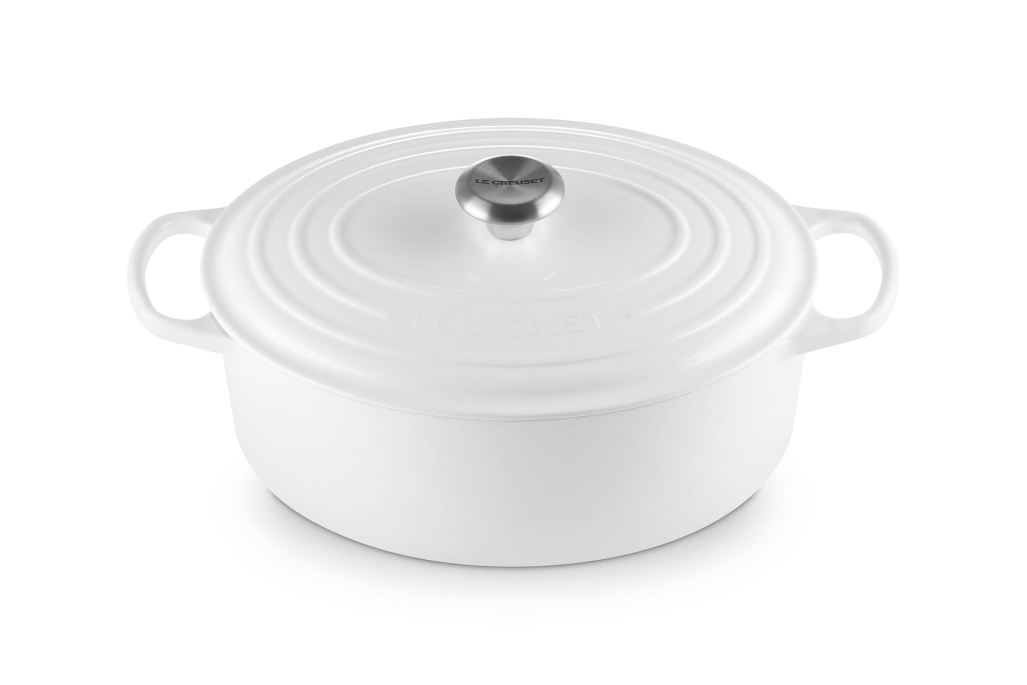 White enameled cast iron oval Dutch oven with lid on a white background
