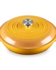 A yellow enameled cast iron Dutch oven with a matching lid and side handles, featuring a silver stainless steel knob on a white background.
