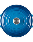 Blue round Le Creuset pot on a white background