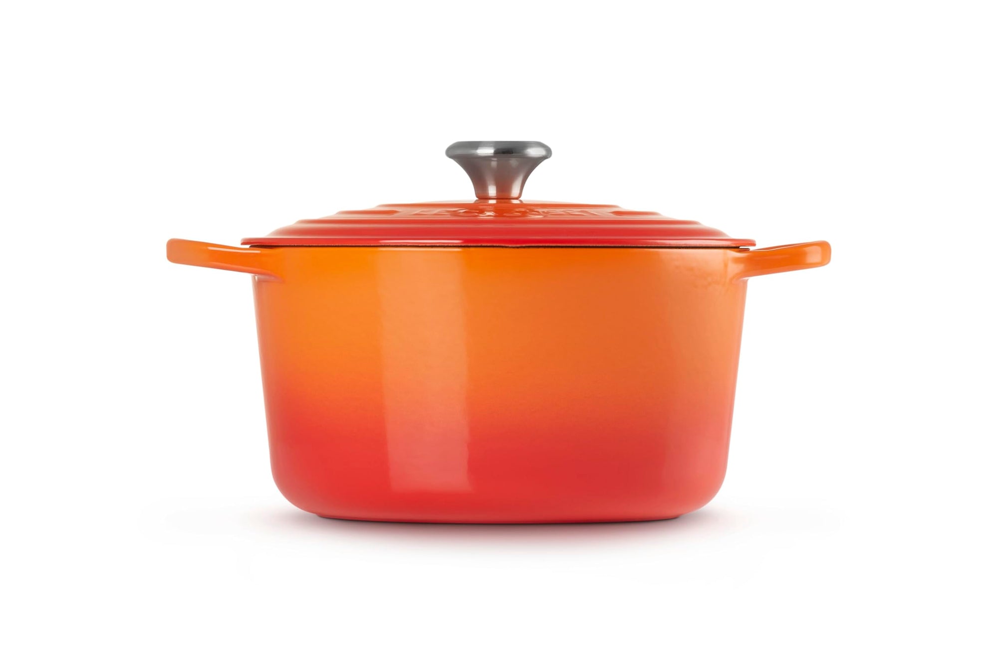 Orange enameled cast iron Dutch oven with a lid on a white background
