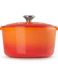 Orange enameled cast iron Dutch oven with a lid on a white background