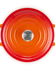 Orange round Le Creuset pot with handles on a white background