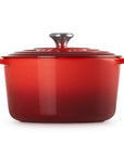Red enameled cast iron Dutch oven with a lid on a white background
