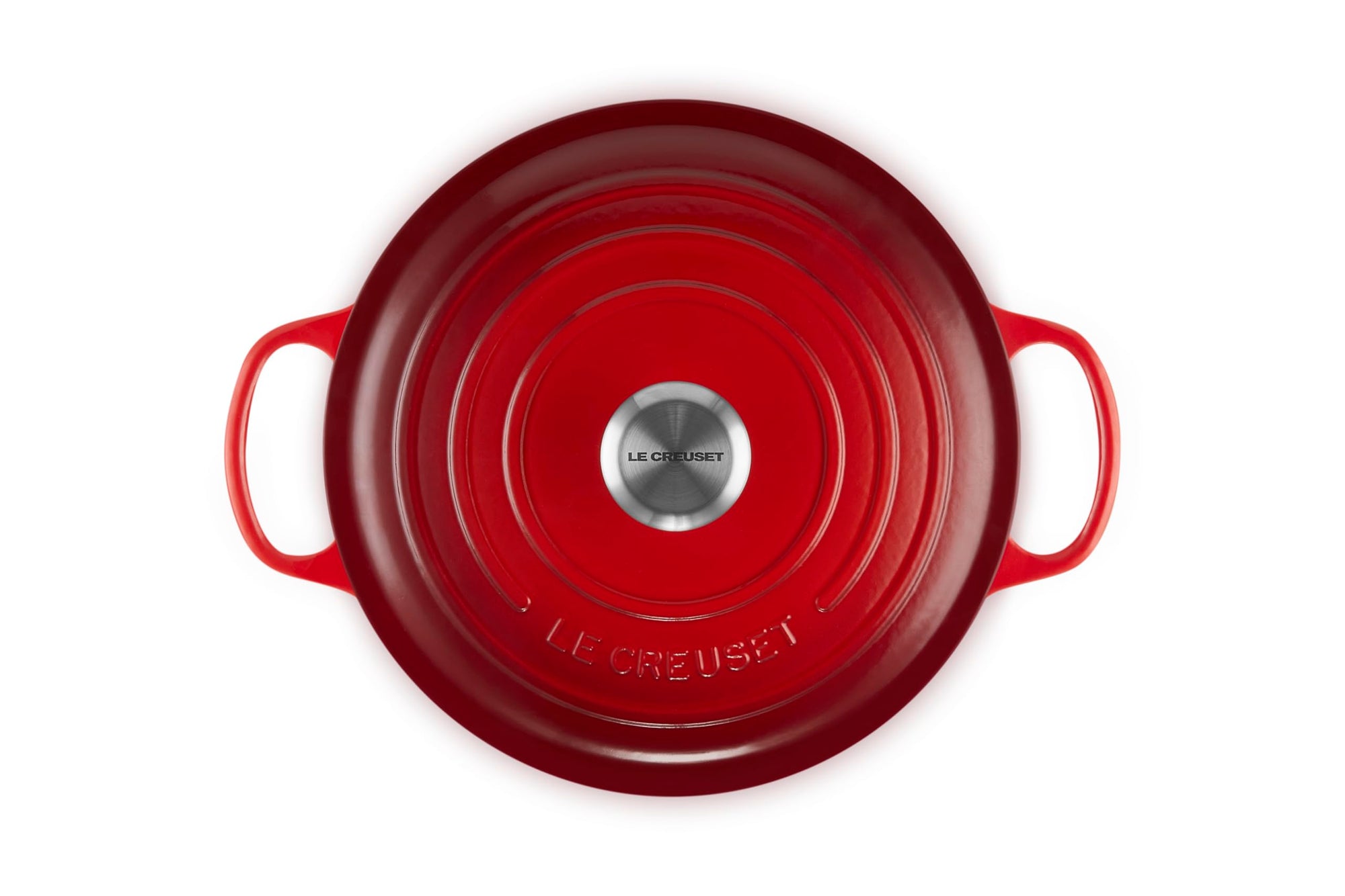 Red Le Creuset cast iron cookware on a white background