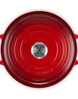 Red Le Creuset cast iron cookware on a white background