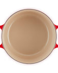 Beige frying pan with red handles on a white background