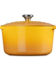 A yellow enameled cast iron Dutch oven with a matching lid and side handles, featuring a silver metal knob on top, set against a plain white background.