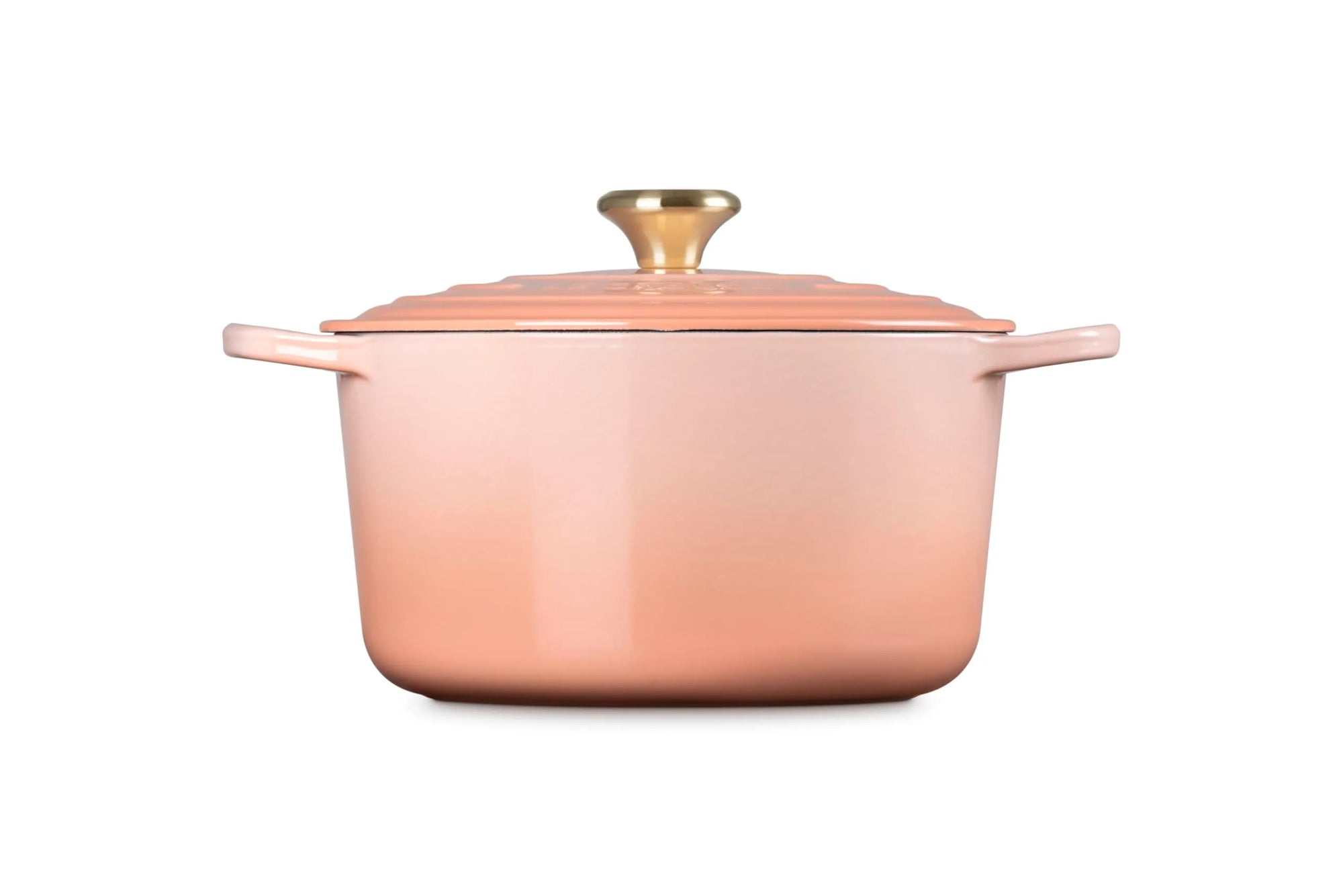A copper-colored enameled cast iron Dutch oven with a matching lid and a gold-toned knob, shown from a front three-quarter angle on a white background.