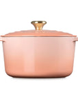 A copper-colored enameled cast iron Dutch oven with a matching lid and a gold-toned knob, shown from a front three-quarter angle on a white background.