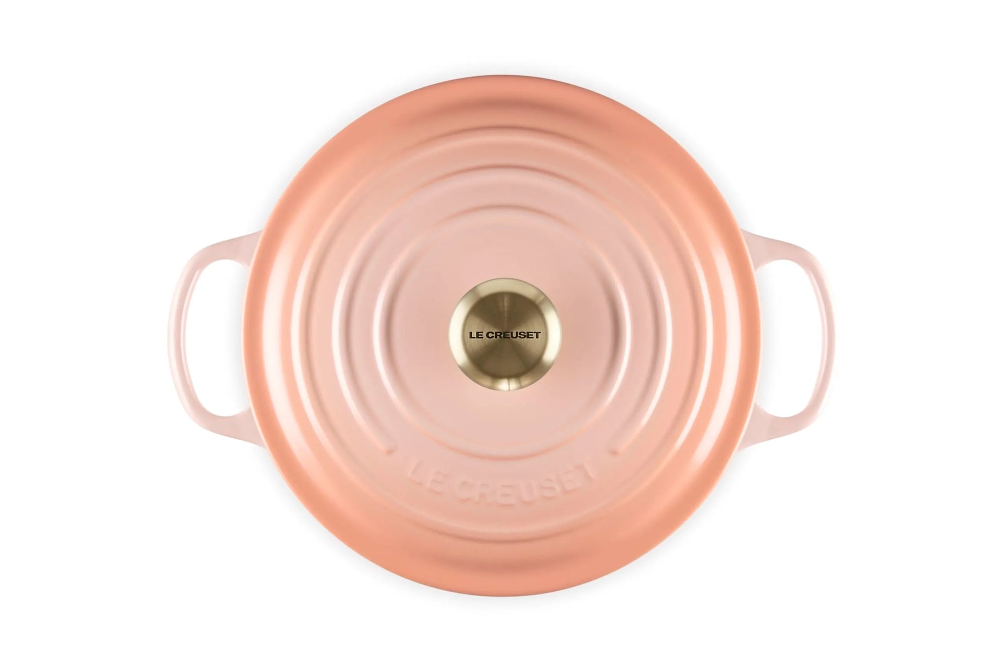 A top-down view of a Le Creuset round Dutch oven lid in a metallic rose gold finish, featuring concentric circular ridges and a gold-toned central knob on a white background.