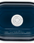 Top view of a Le Creuset oval roasting pan in a deep navy blue color, shown from a top-down perspective on a white background.