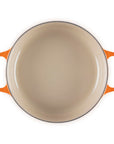 Top view of 3.5 qt flame Le Creuset Signature Round Wide Dutch Oven displayed on a white background