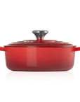 Side view of 3.5 qt cerise Le Creuset Signature Round Wide Dutch Oven with a lid displayed on a white background