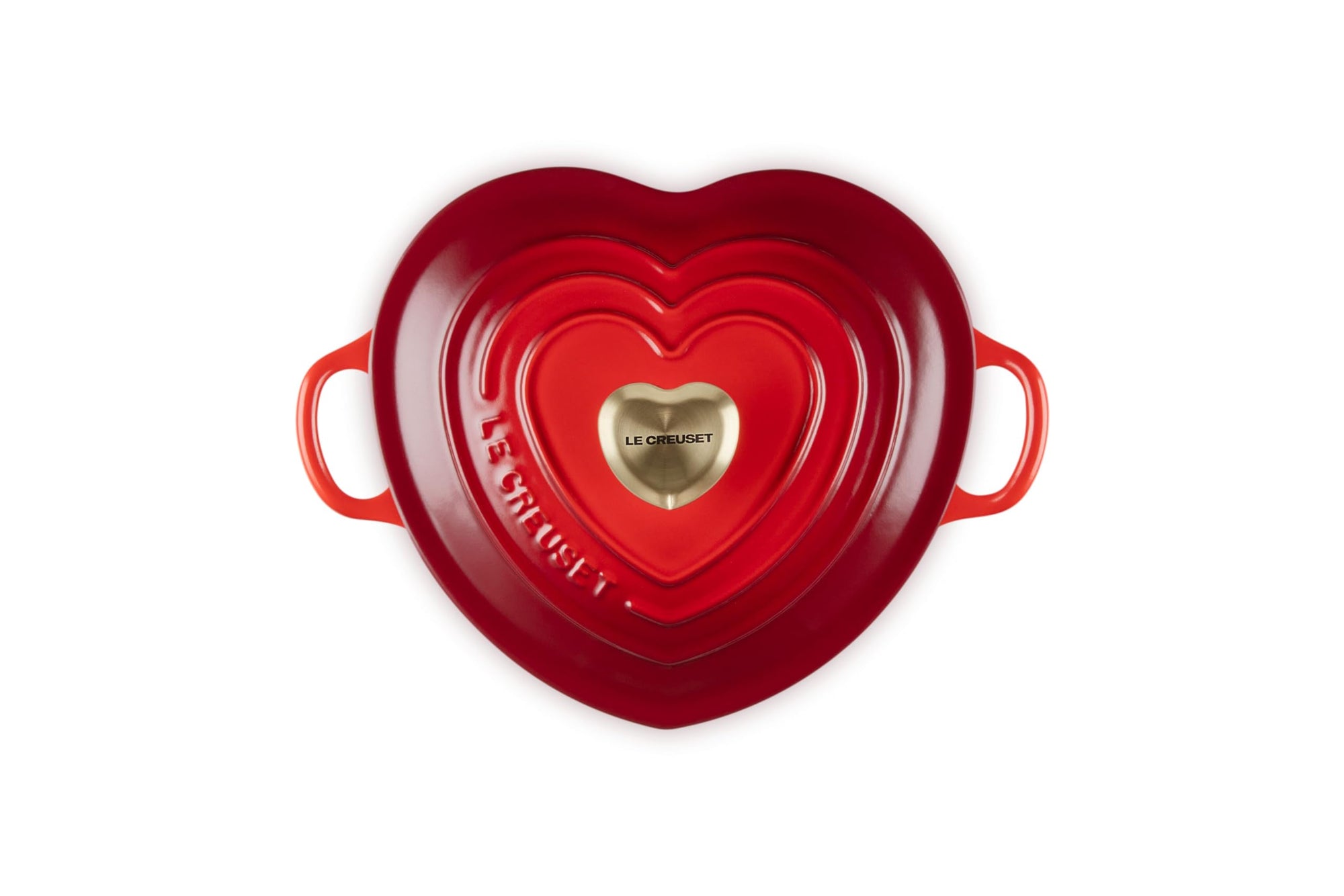 Top view of cerise heart shaped 1.25 qt cocotte with handles and a light gold heart knob displayed on a white background