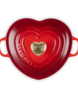 Top view of cerise heart shaped 1.25 qt cocotte with handles and a light gold heart knob displayed on a white background