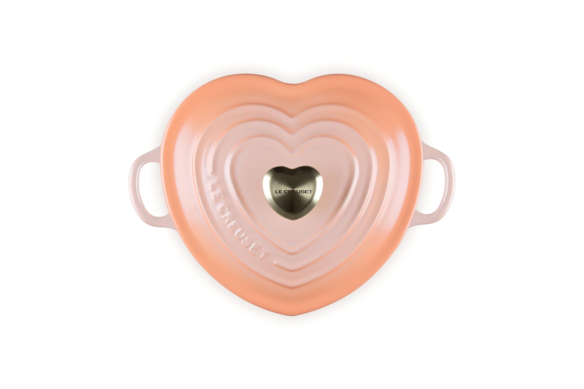 Top view of peche heart shaped 1.25 qt cocotte with handles and a light gold heart knob displayed on a white background