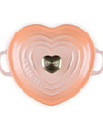 Top view of peche heart shaped 1.25 qt cocotte with handles and a light gold heart knob displayed on a white background