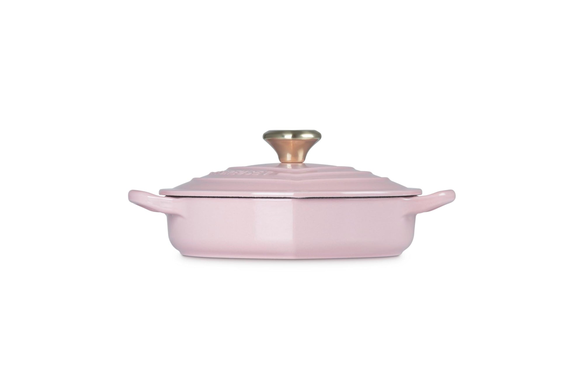 Side view of chiffon pink heart shaped 1.25 qt cocotte with handles and a light gold heart knob displayed on a white background