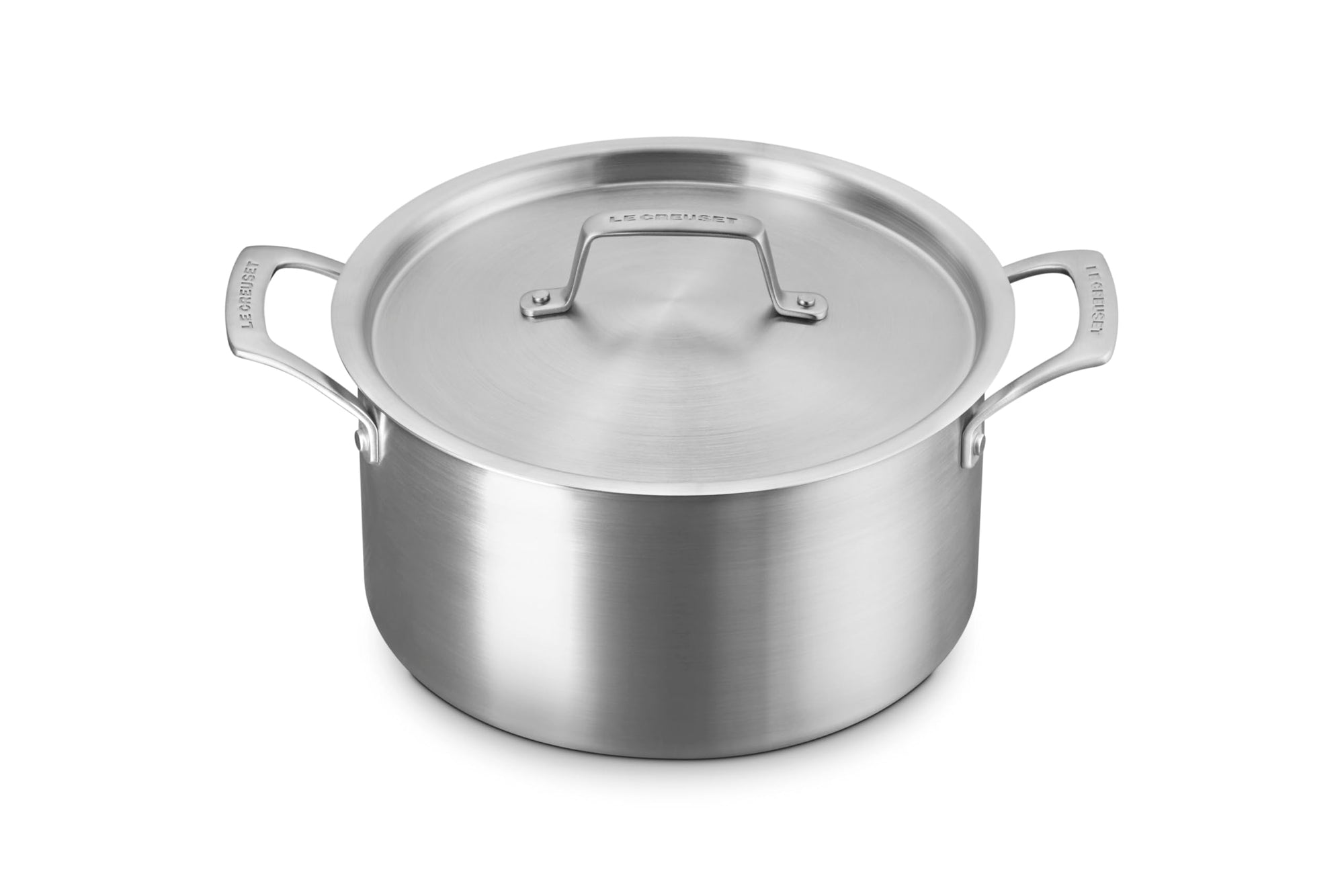 Le Creuset stainless steel pot with handles and lid displayed on a white background