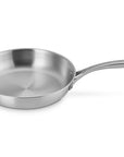 Le Creuset stainless steel saucepan with handles displayed on a white background