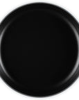 A top-down view of a round cast iron skillet with a black interior and a dark teal blue exterior handles, shown on a solid white background.